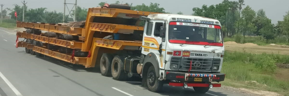 Care Container Lines trailer carrying steel cargo on the highway